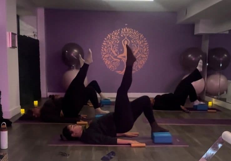Three clients working on mats in the Bronzeville Pilates studio